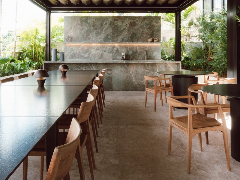 Espaço de convivência com mesa longa e cadeiras de madeira